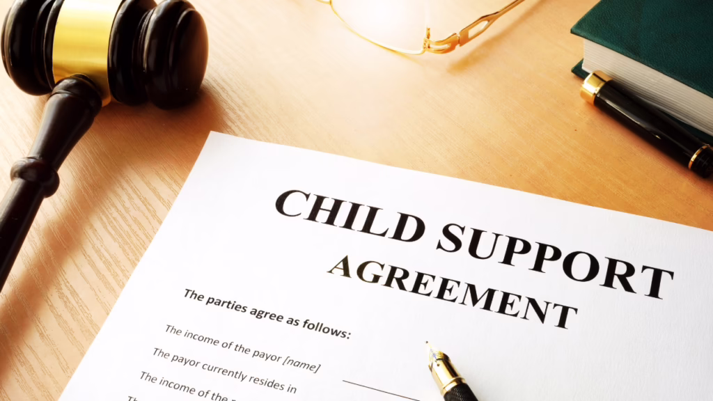 How Child Support Is Calculated in Nevada: The Formula Explained 1 A child support agreement document on a desk with a gavel, pen, glasses, and a green book nearby. © Marathon Law Group