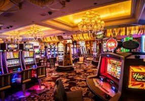 Casino interior with brightly lit slot machines under elegant chandeliers, illustrating gambling law regulations and legal casino gaming environment. © Marathon Law Group