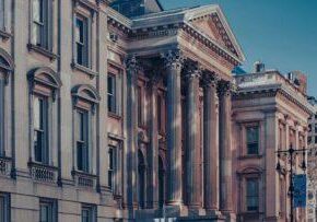 Historic law building with grand columns, blue sky above, representing justice, legal services, and trusted law expertise in a classic architectural setting. © Marathon Law Group